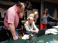 team discusses plans around a laptop